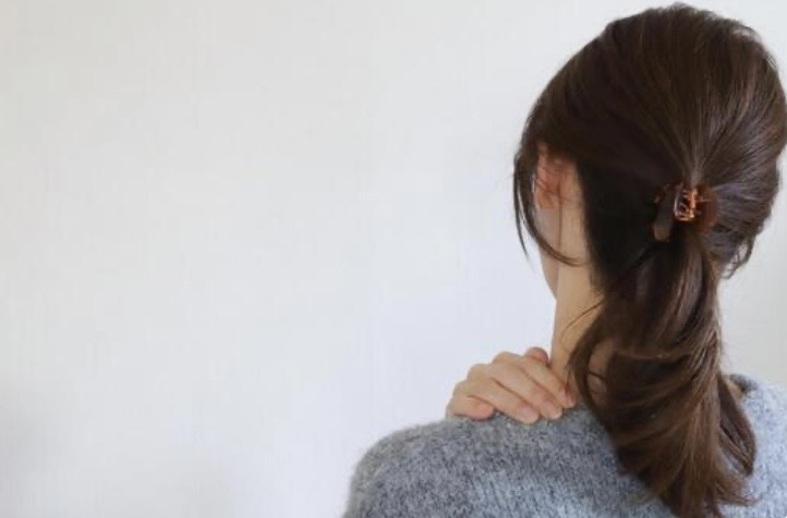 肩を押さえる女性