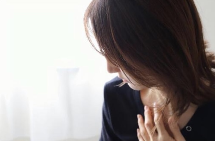 胸を押さえる女性