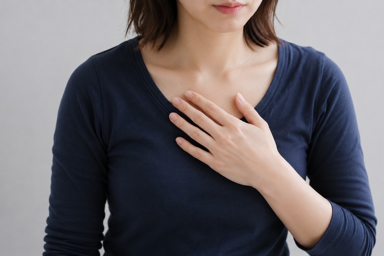 息苦しそうに胸に手を当てる女性