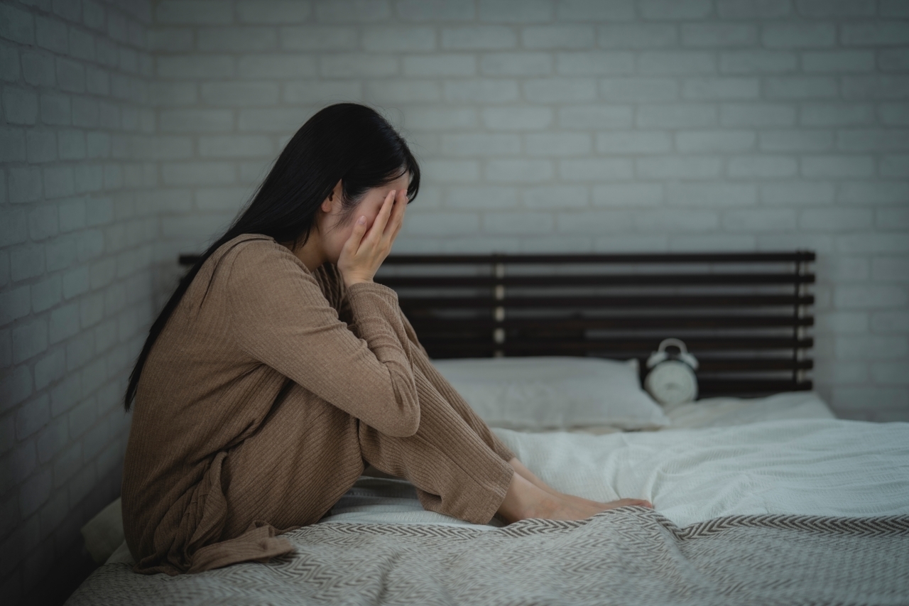 ベッドの上で泣く女性