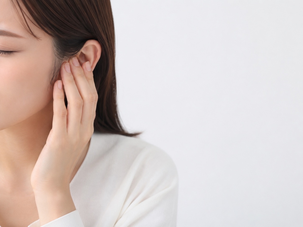 耳を押さえる女性