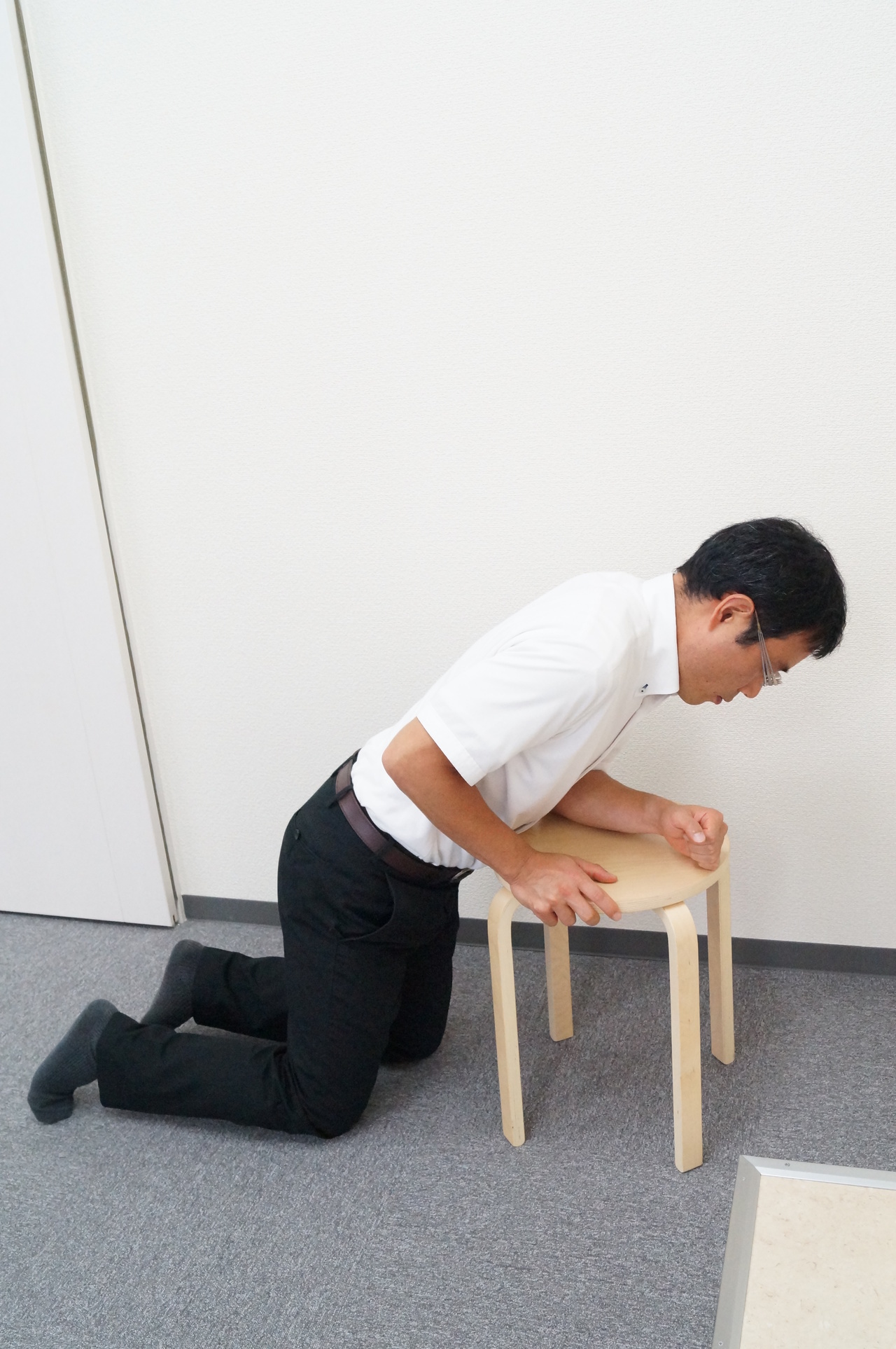 腰痛で椅子に倒れ掛かる男性