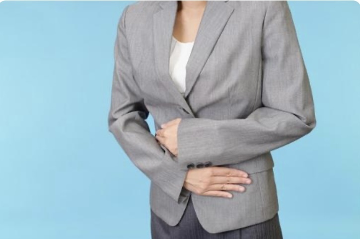 お腹を抑える女性