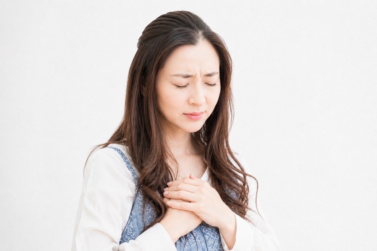 胸を押さえる女性