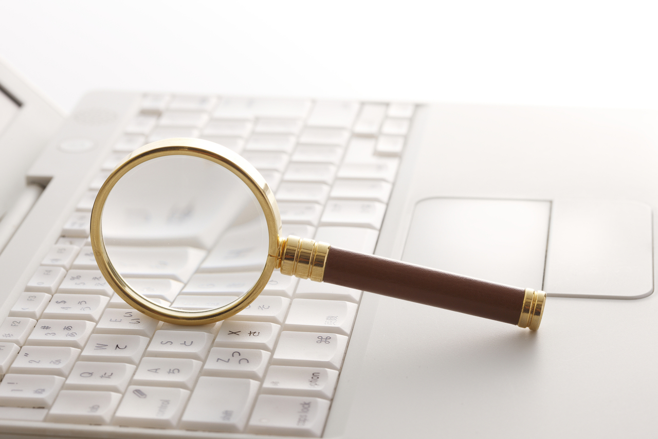 虫眼鏡とパソコン