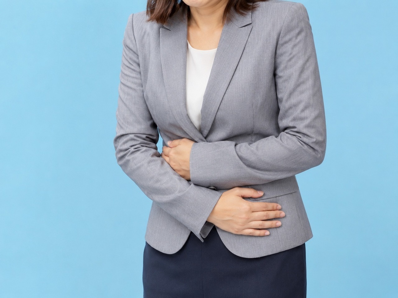 お腹を抑える女性