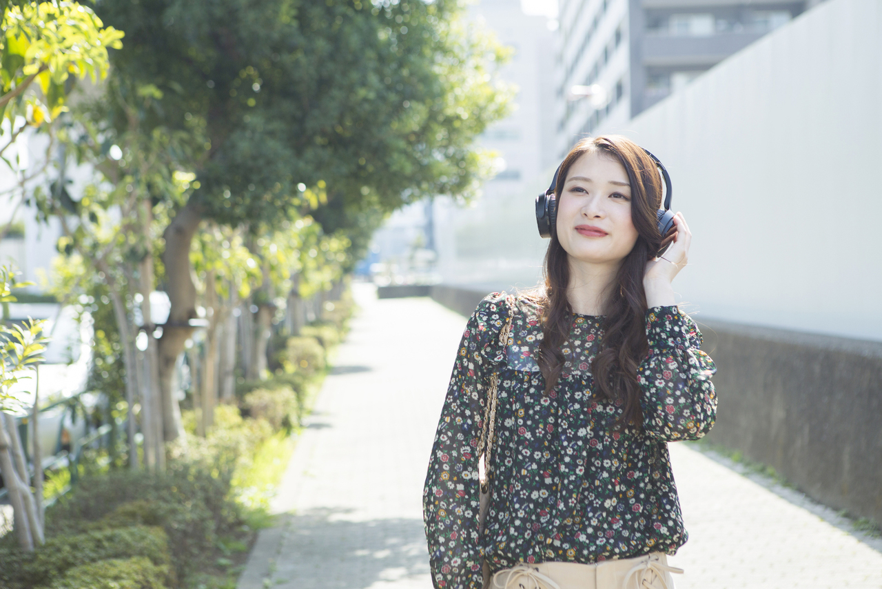 音楽を聴きながら散歩する女性