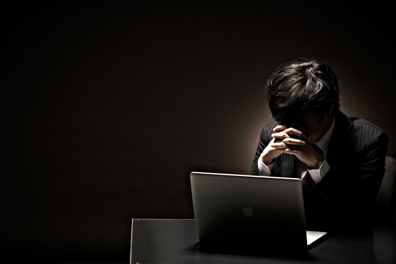 PCの前で絶望的になる男性