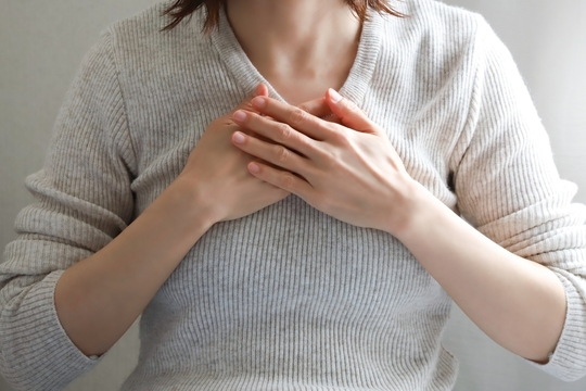 胸を押さえる女性