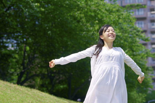 自然の中で深呼吸する女性