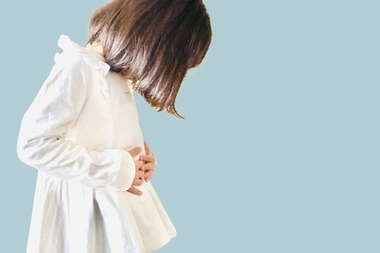 小さな女の子がお腹をおさえている様子