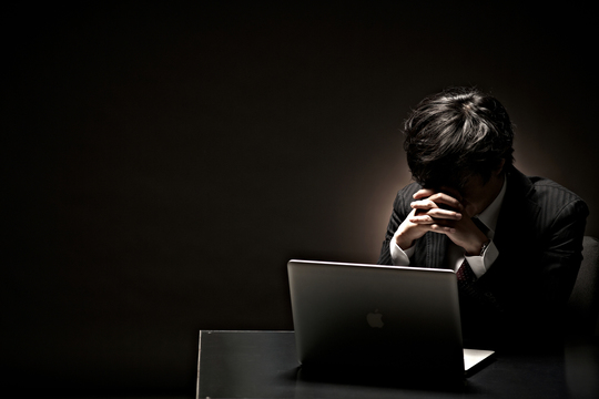 パソコンの前で絶望している男性